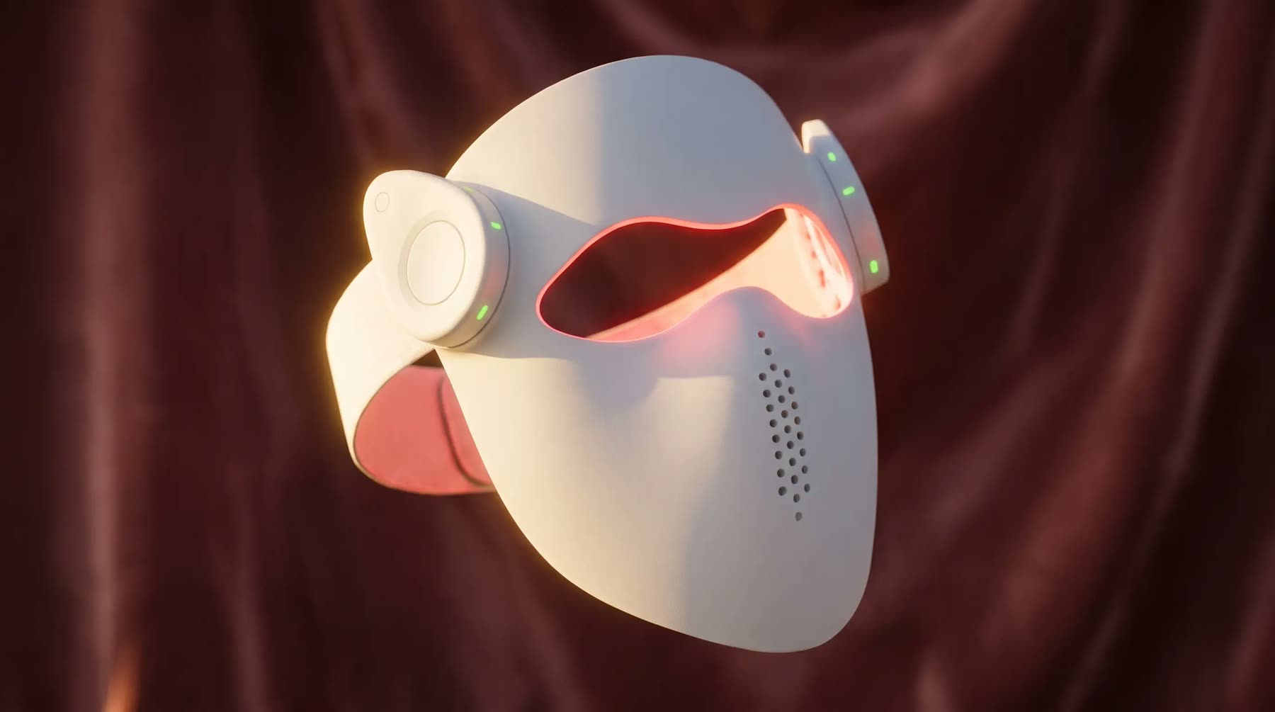The P.S. LaserMask with its red laser array glowing on dusty-rose silk